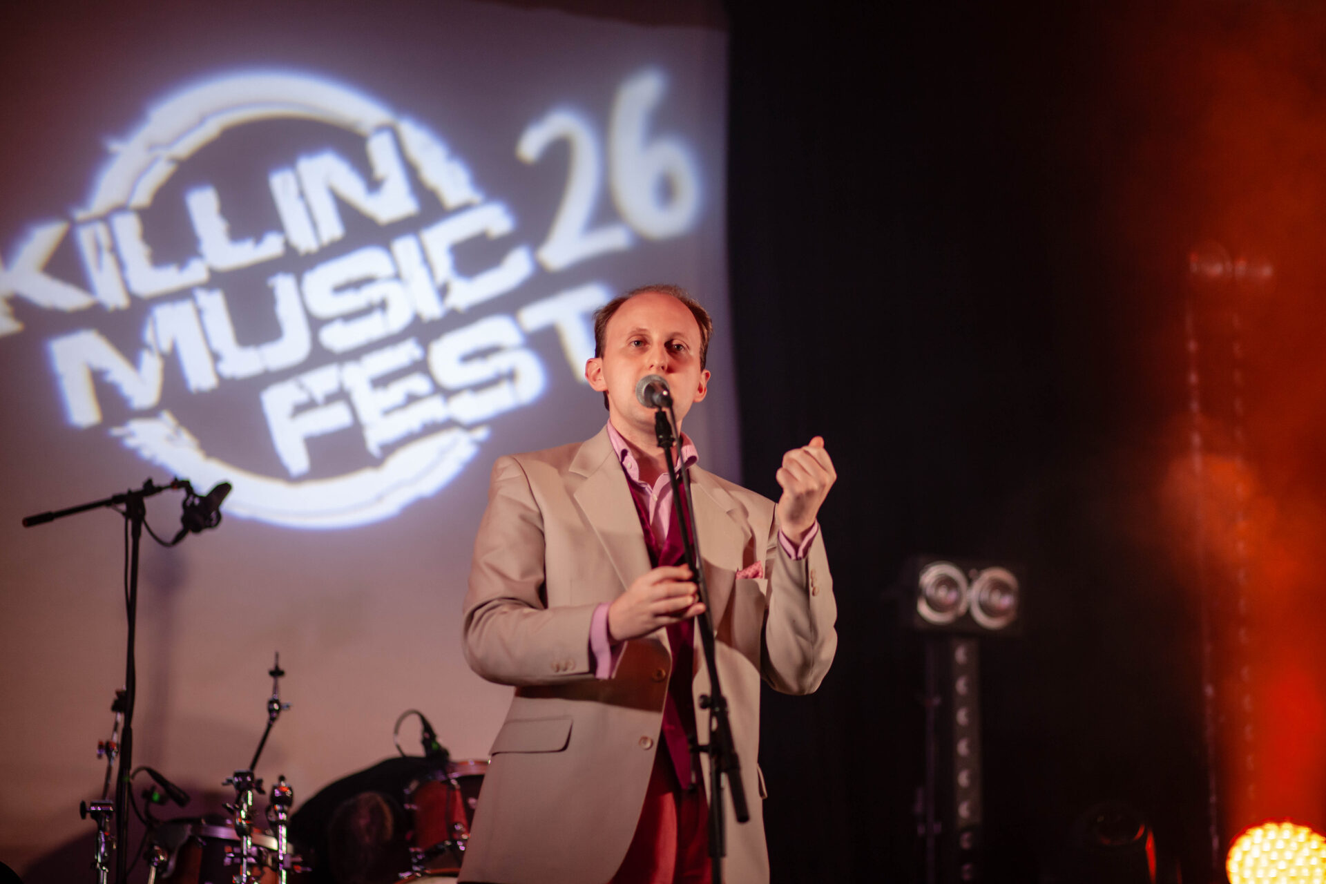 Singer performing in front of the large Killin Music Fest logo