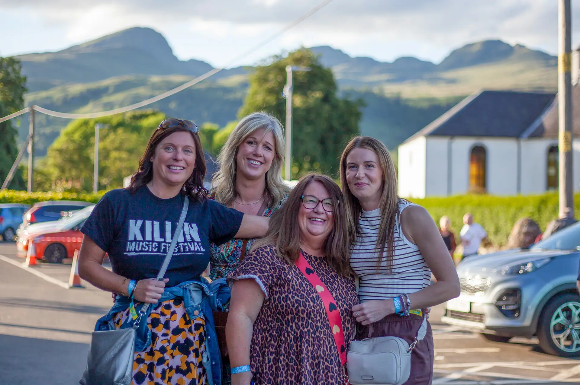 Friends arriving at the festival with the Highland hills behind
