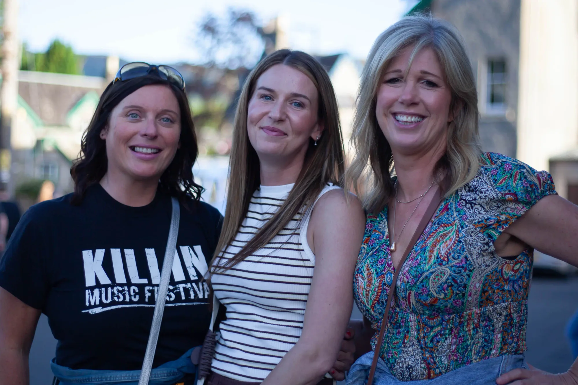 Three friends on the street at golden hour in festival t-shirts
